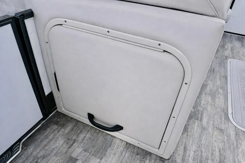Slide: The Image of 2019 Crest 250 LUSD boat storage compartment with gray upholstery and black handle. - 25