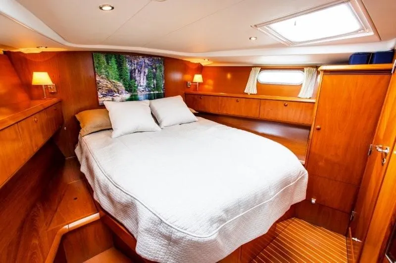 Slide: The Image of Luxurious cabin interior of 2007 Jeanneau Sun Odyssey 54 DS yacht, featuring cozy bed and wooden decor. - 11