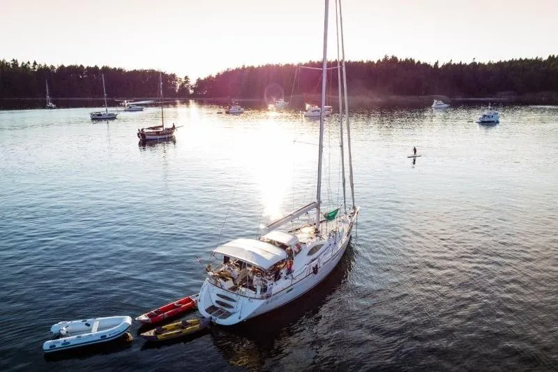 Slide: The Image of Jeanneau Sun Odyssey 54 DS 2007 sailboat anchored in serene waters at sunset. - 15