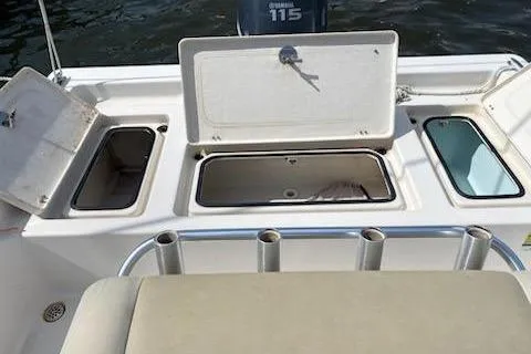 Slide: The Image of 2009 Cobia 191 Bay boat with open storage compartments and rod holders. - 5