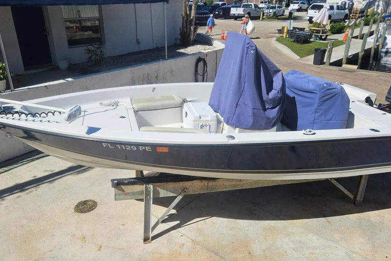 Slide: The Image of 2009 Cobia 191 Bay boat on trailer, covered seats, dockside view. - 8