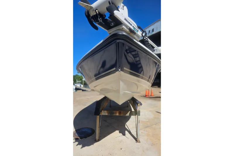 Slide: The Image of 2009 Cobia 191 Bay boat on stand, viewed from the front, under clear blue sky. - 9