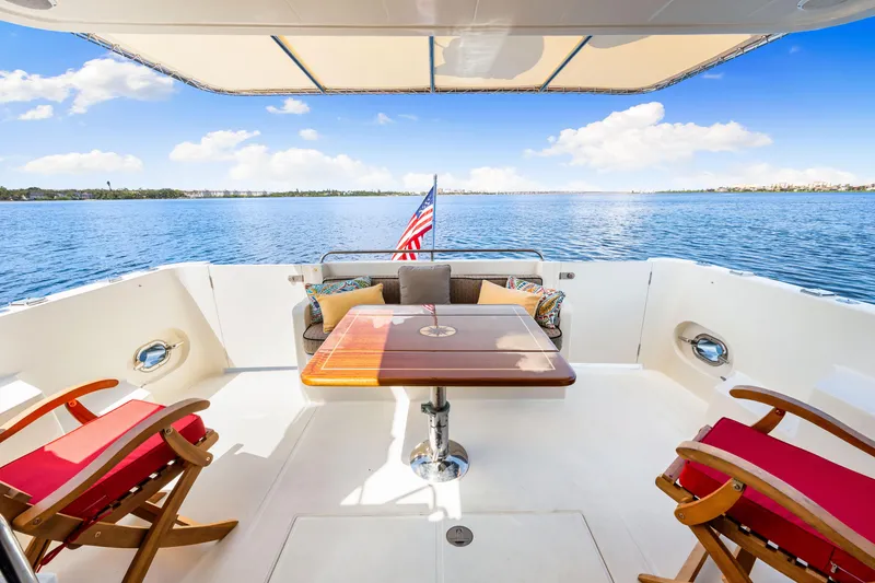 Slide: The Image of 2007 Hampton 558 Pilothouse yacht deck with seating, table, and ocean view. - 54