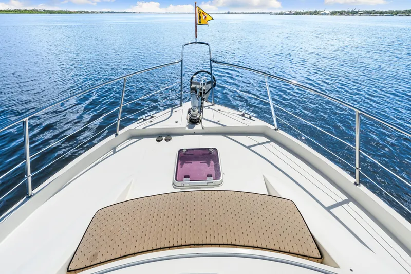 Slide: The Image of Bow view of 2007 Hampton 558 Pilothouse yacht on calm blue waters. - 61