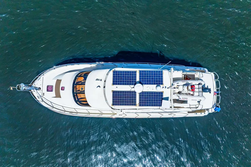Slide: The Image of Aerial view of 2007 Hampton 558 Pilothouse yacht with solar panels on open water. - 77