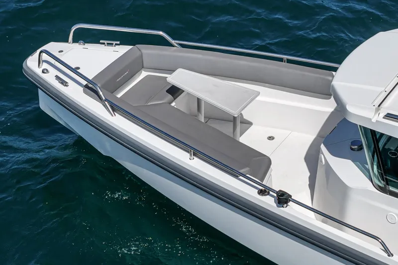 Slide: The Image of 2019 Axopar 28 CABIN boat with seating and table on calm water. - 10