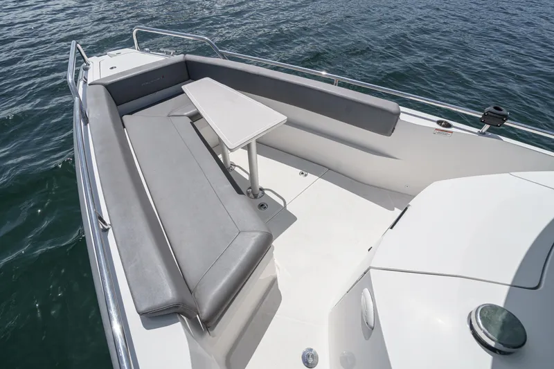 Slide: The Image of 2019 Axopar 28 CABIN boat with spacious seating and table on deck. - 11