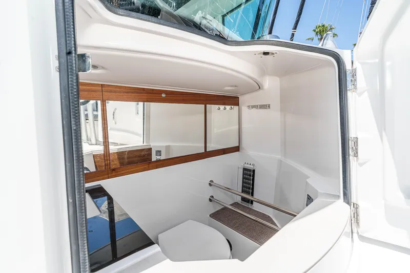 Slide: The Image of 2019 Axopar 28 CABIN interior with modern bathroom and wooden accents. - 13