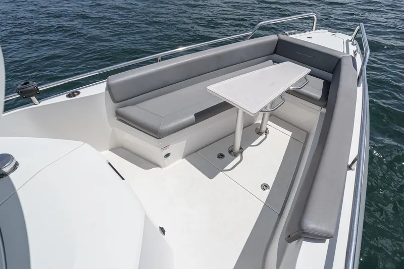 Slide: The Image of 2019 Axopar 28 CABIN boat with sleek seating and table on open water. - 14