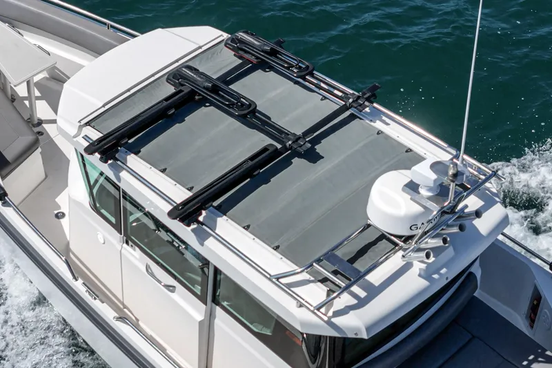 Slide: The Image of 2019 Axopar 28 CABIN boat cruising on water, top view of cabin and roof. - 16
