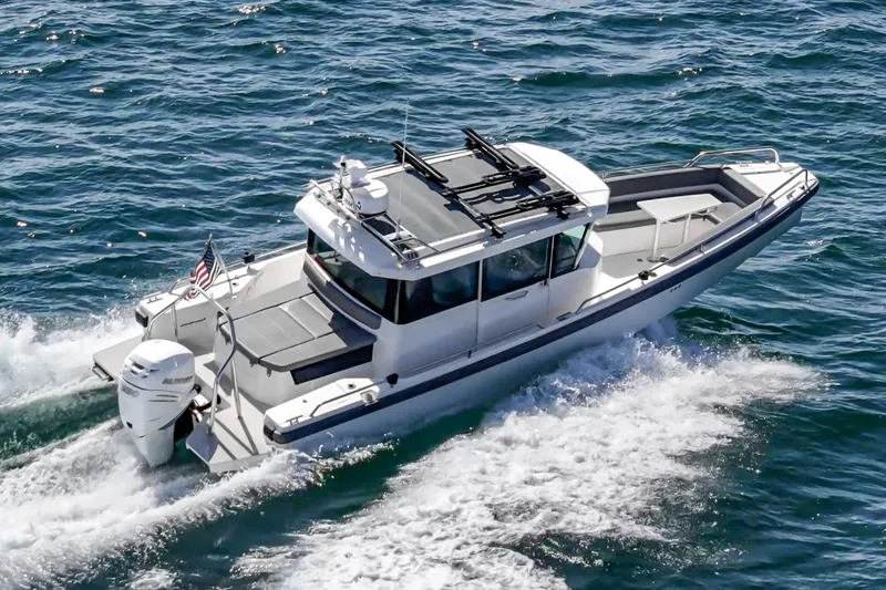 Slide: The Image of 2019 Axopar 28 CABIN boat cruising on open water, side view. - 2