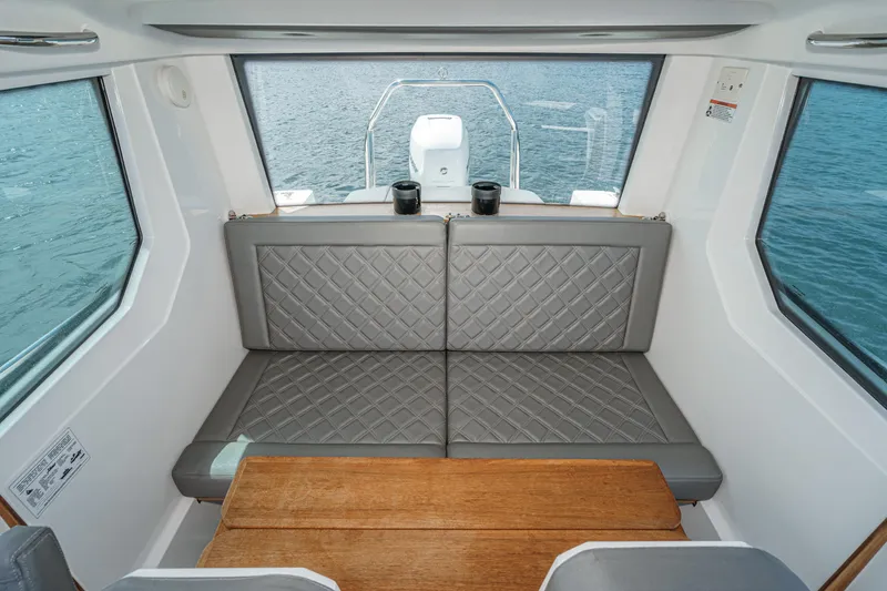 Slide: The Image of Interior of 2019 Axopar 28 CABIN with gray seating and wooden table. - 26