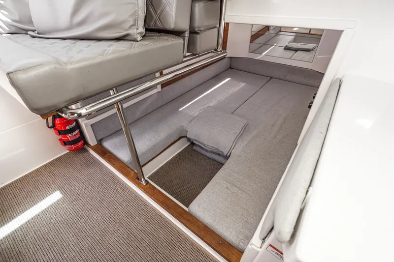 Slide: The Image of 2019 Axopar 28 CABIN interior with gray seating and fire extinguisher. - 30