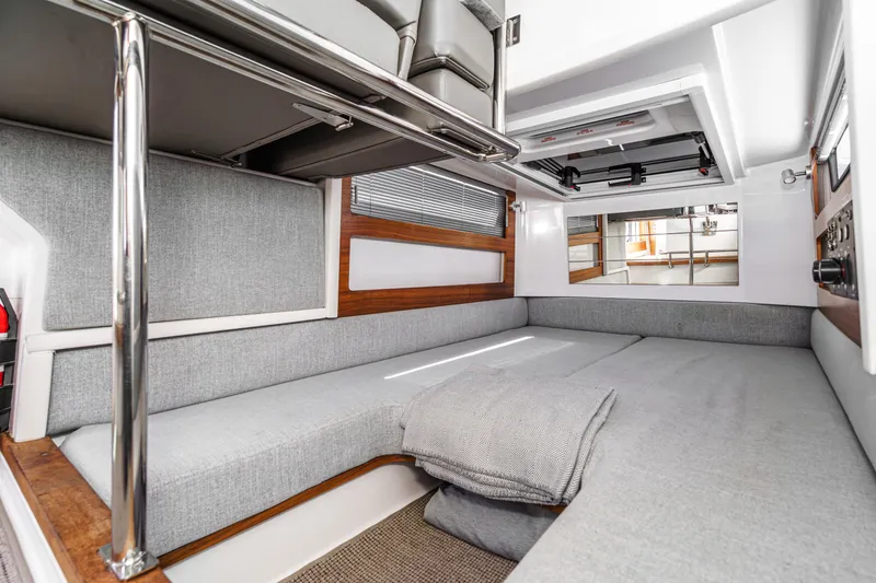 Slide: The Image of 2019 Axopar 28 CABIN interior with modern gray seating and wooden accents. - 31