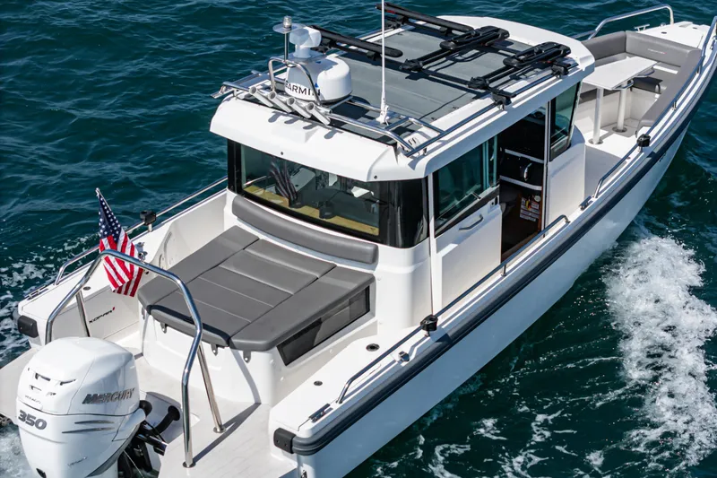 Slide: The Image of 2019 Axopar 28 CABIN boat cruising on open water with American flag. - 35