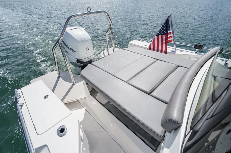 Slide: The Image of 2019 Axopar 28 CABIN boat with Mercury engine and American flag on open water. - 37