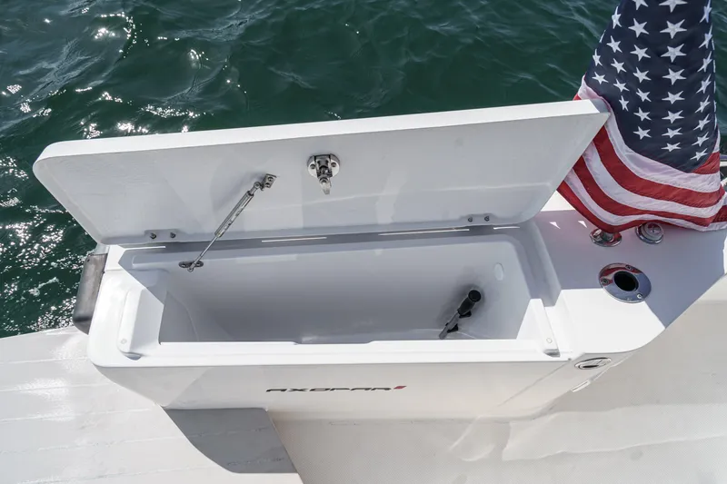 Slide: The Image of Open storage compartment on 2019 Axopar 28 CABIN boat with American flag. - 41