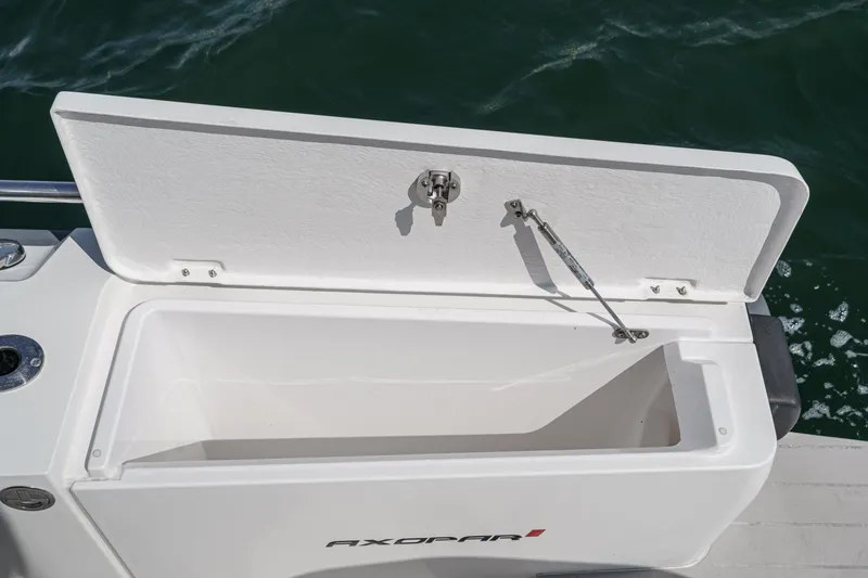 Slide: The Image of Open storage compartment on 2019 Axopar 28 CABIN boat, with visible latch and hydraulic arm. - 42