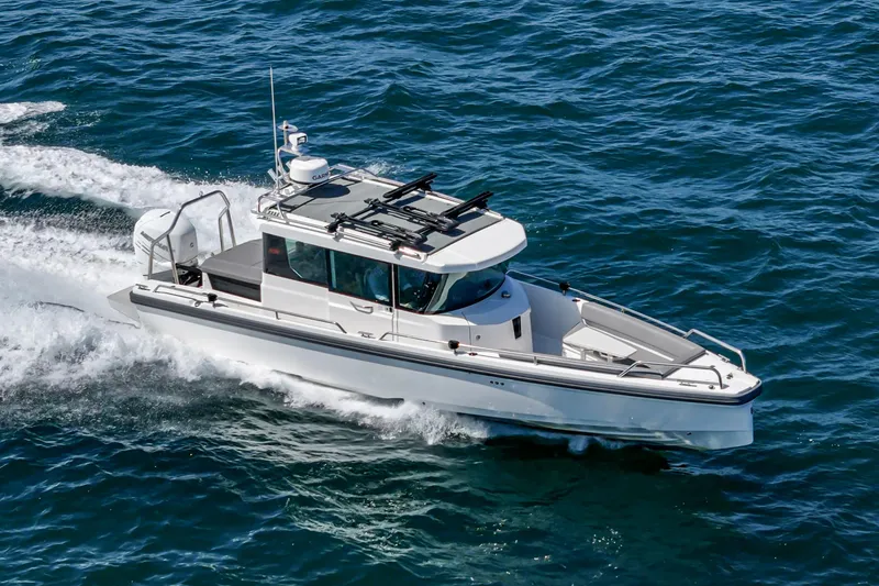 Slide: The Image of 2019 Axopar 28 CABIN boat cruising on open water. - 5