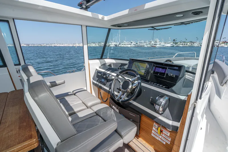 Slide: The Image of Interior of 2019 Axopar 28 CABIN boat with modern dashboard and steering wheel. - 7