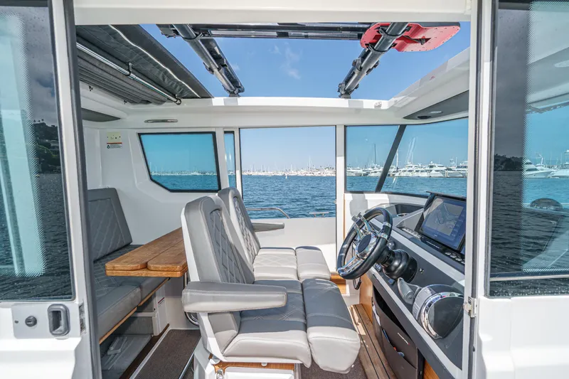 Slide: The Image of Interior of 2019 Axopar 28 CABIN boat with steering wheel and seating. - 9