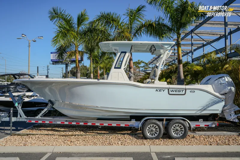 The Image of 2026 Key West 260 Center Console boat on trailer, parked near palm trees. - 1