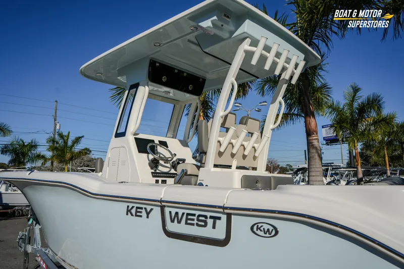 Slide: The Image of 2026 Key West 260 Center Console boat with T-top, displayed outdoors near palm trees. - 24