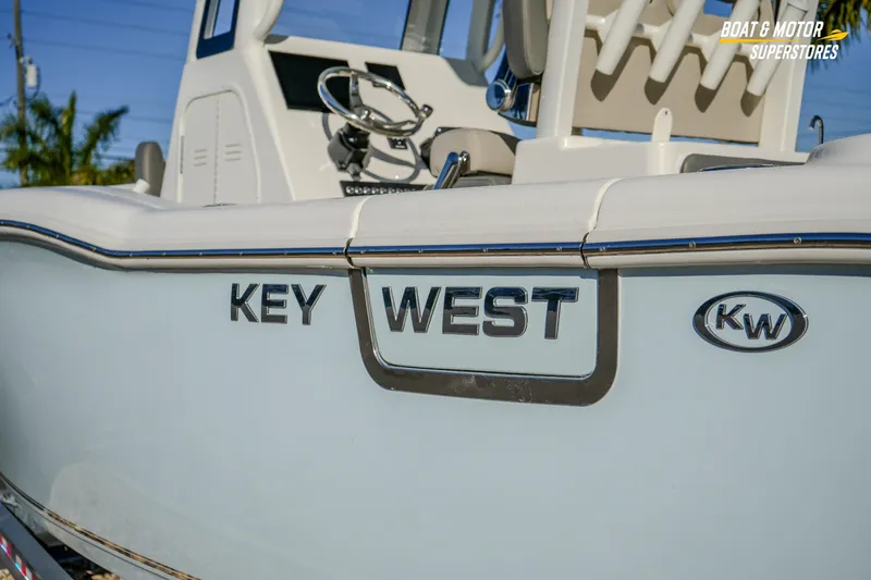 Slide: The Image of 2026 Key West 260 Center Console boat, side view with logo and steering wheel visible. - 25