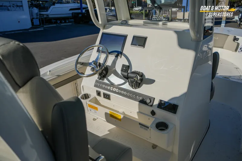 Slide: The Image of 2026 Key West 260 Center Console boat dashboard with steering wheel and controls. - 37