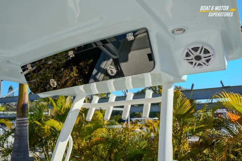 Slide: The Image of 2026 Key West 260 Center Console boat with rod holders and speaker, surrounded by tropical foliage. - 46