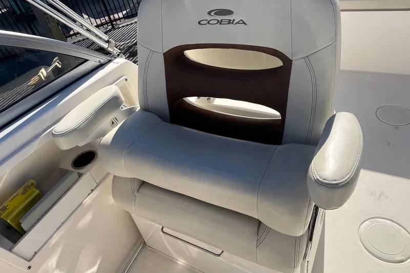 Slide: The Image of Captain's chair on 2023 Cobia 220 Dual Console boat, featuring comfortable armrests and sleek design. - 11
