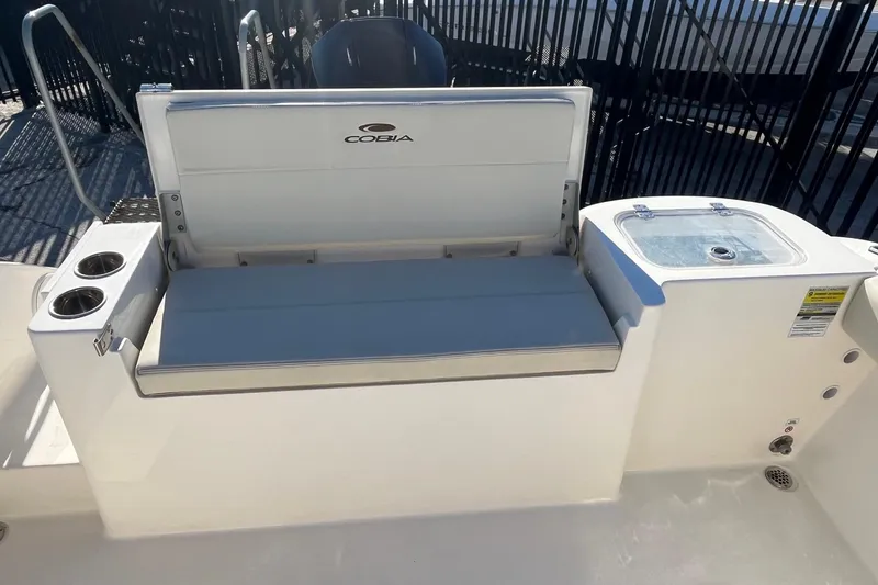 Slide: The Image of 2023 Cobia 220 Dual Console boat interior with seating and cup holders. - 12