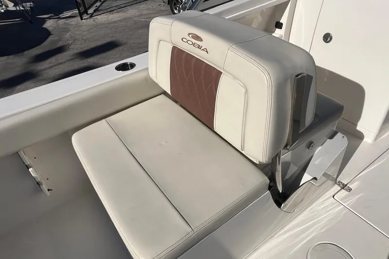 Slide: The Image of 2023 Cobia 220 Dual Console boat seat with white and brown upholstery. - 14