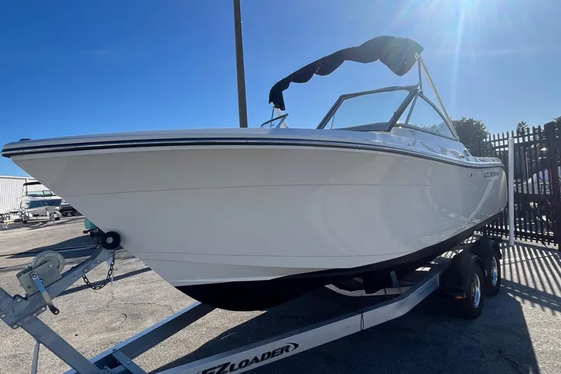 Slide: The Image of 2023 Cobia 220 Dual Console boat on trailer under clear blue sky. - 3