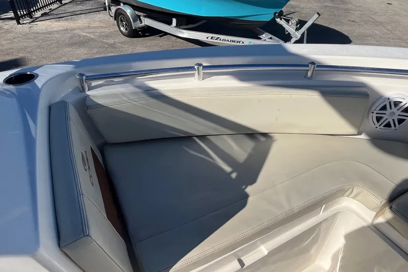 Slide: The Image of 2023 Cobia 220 Dual Console boat interior with cushioned seating and speaker. - 9