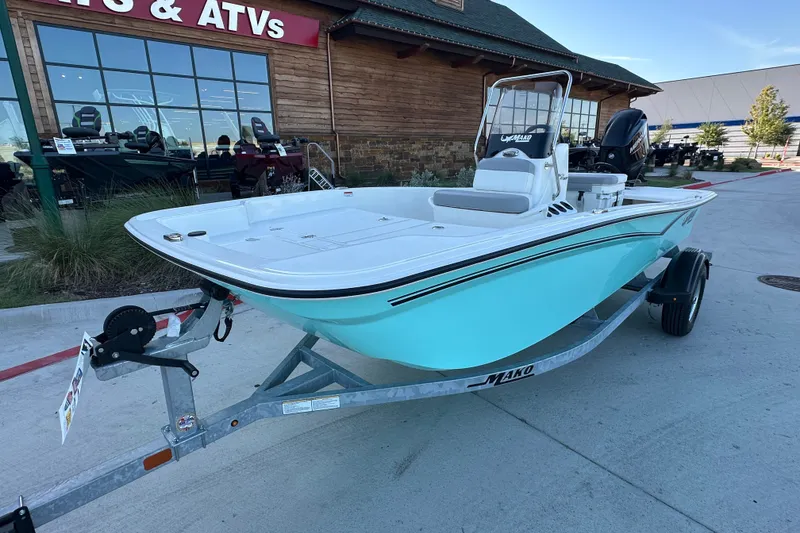 Slide: The Image of 2026 Mako Pro Skiff 15 CC boat on trailer outside a store. - 8