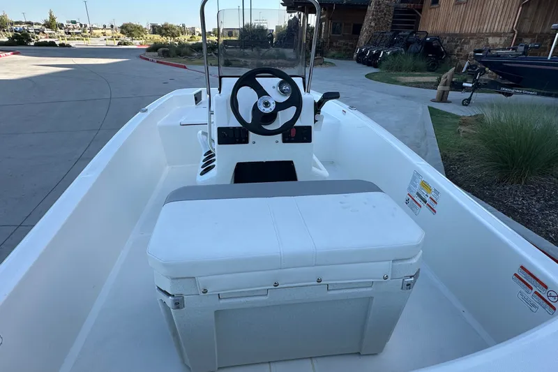 Slide: The Image of 2026 Mako Pro Skiff 15 CC boat interior with steering console and seating. - 16