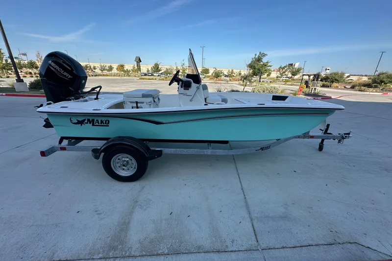 Slide: The Image of 2026 Mako Pro Skiff 15 CC boat on trailer, parked outdoors under clear sky. - 13
