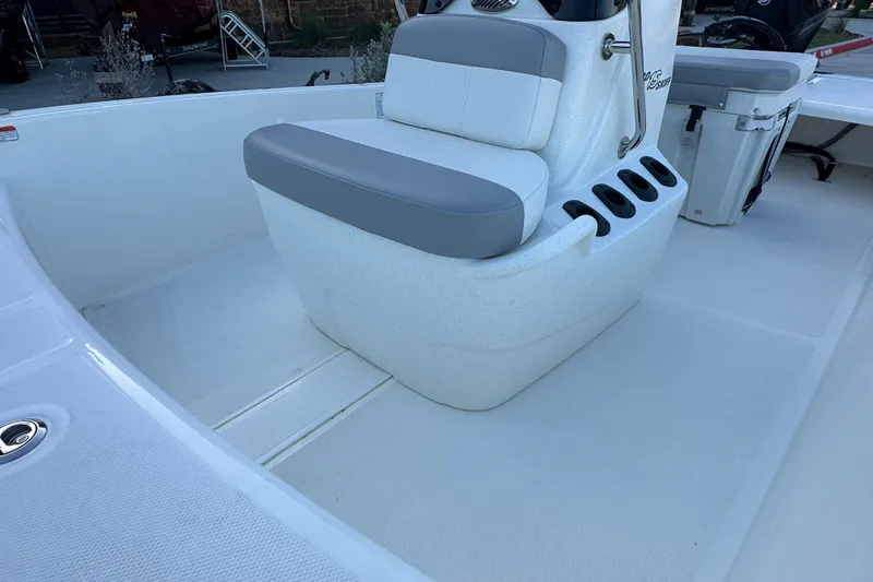 Slide: The Image of 2026 Mako Pro Skiff 15 CC boat interior with cushioned seating and rod holders. - 20