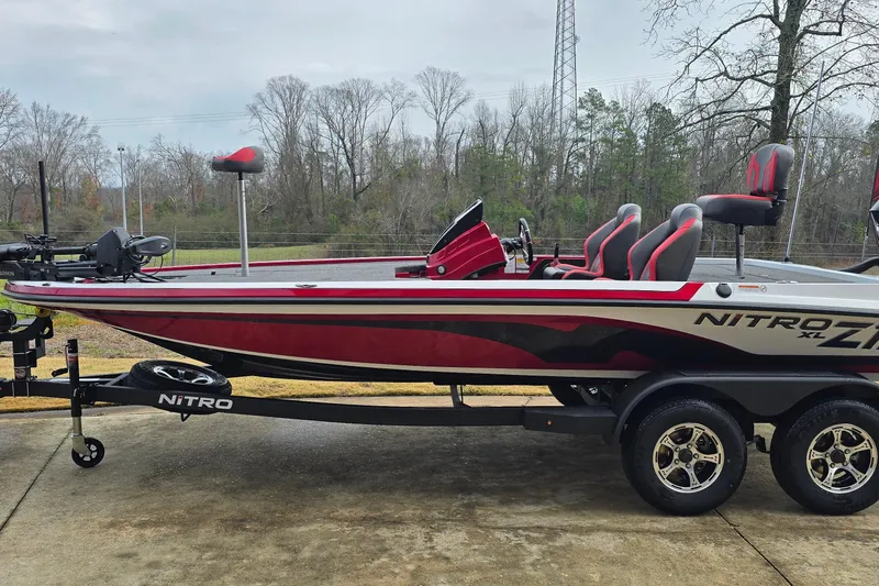 Slide: The Image of 2026 Nitro Z19 XL Pro bass boat on trailer, red and black design, parked outdoors. - 0
