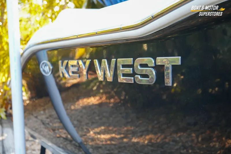 Slide: The Image of 2023 Key West 219 FS boat side view with logo, outdoors. - 10