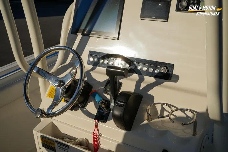 Slide: The Image of 2023 Key West 219 FS boat dashboard with steering wheel and controls. - 21
