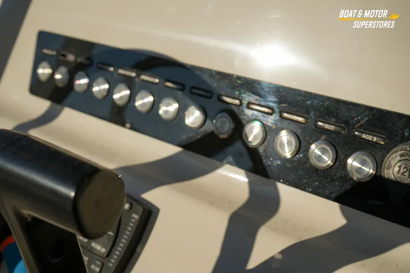 Slide: The Image of 2023 Key West 219 FS boat dashboard with control switches and throttle. - 22