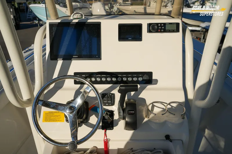 Slide: The Image of 2023 Key West 219 FS boat dashboard with steering wheel and navigation controls. - 23