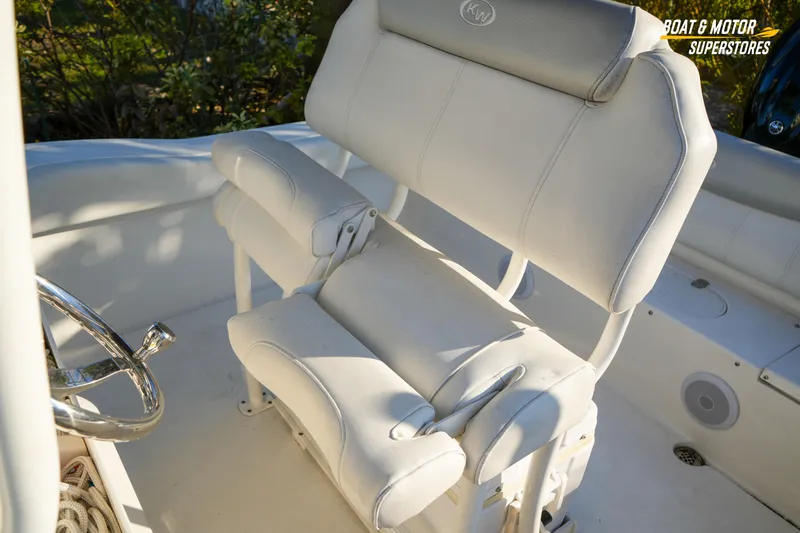 Slide: The Image of 2023 Key West 219 FS boat interior with white cushioned seating and steering wheel. - 29
