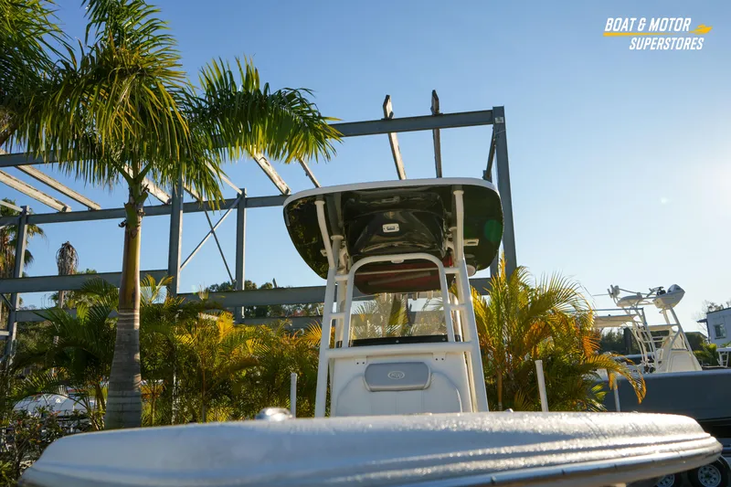 Slide: The Image of 2023 Key West 219 FS boat displayed outdoors with palm trees and clear sky. - 4