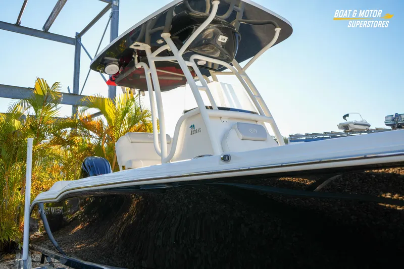 Slide: The Image of 2023 Key West 219 FS boat displayed outdoors with palm trees and clear sky. - 5