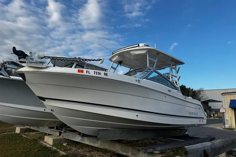 The Image of 2016 Robalo R247 Dual Console boat on display under a blue sky. - 1