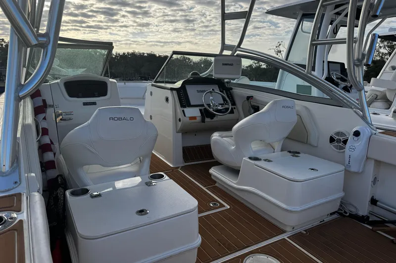 Slide: The Image of 2016 Robalo R247 Dual Console boat interior with white seating and modern dashboard. - 12