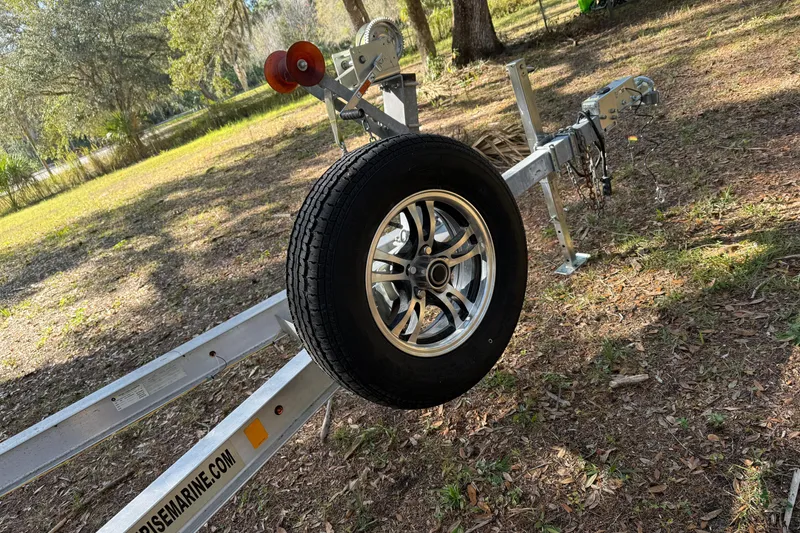 Slide: The Image of Trailer for 2016 Robalo R247 Dual Console boat in a wooded area. - 15